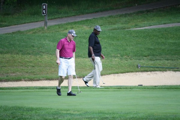 Bill Jones (l), chapter president, and Alvie Johnson, chapter executive vice president, strategize for the winning putt during the chapter’s fundraising golf tournament in May.